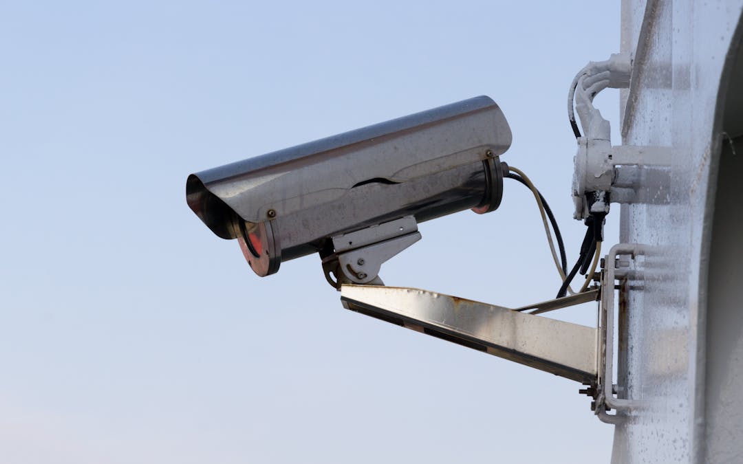 Outdoor CCTV security camera mounted on a wall, evidence-grade documentation context